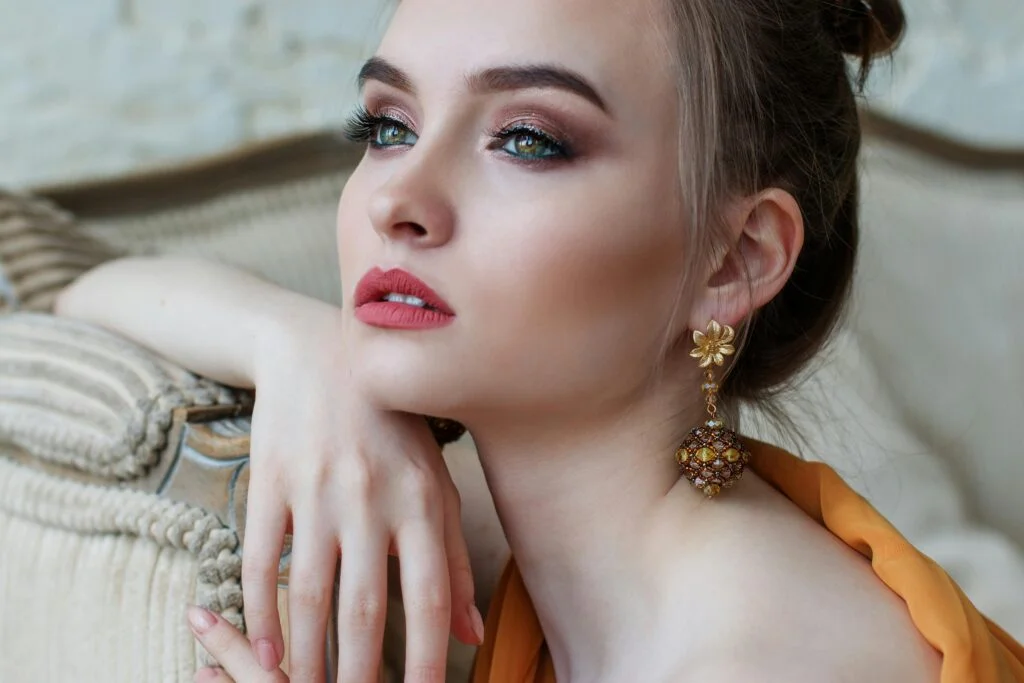 Stunning close-up portrait of a woman with elegant makeup and jewelry, epitomizing modern fashion and beauty.